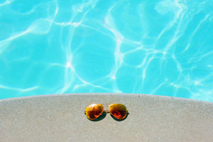 Sunglasses beside swimming pool