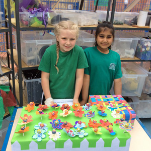Two girls taking part in the Fiver Challenge selling products on a stall