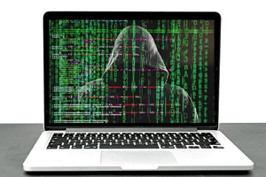 Laptop with photo of faceless criminal wearing a hoodie