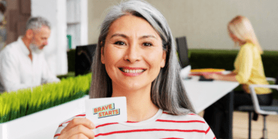Woman holding Brave Starts business card