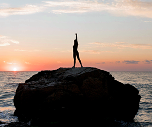 resilient woman standing on a rock